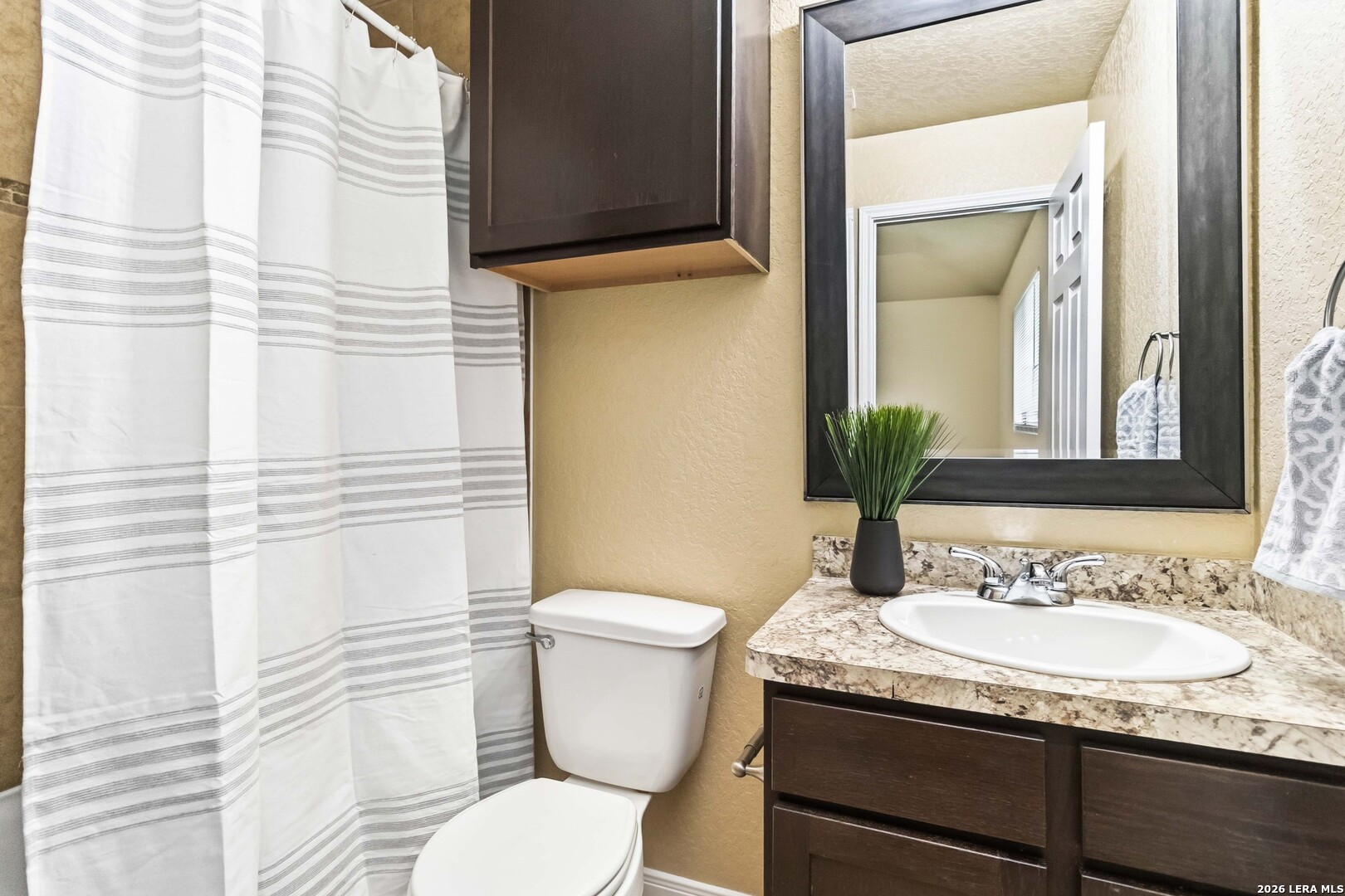 8711 8th Street, Unit 1 Converse, TX 78109 - Photo 15 of 25 a bathroom with a granite countertop sink and a mirror