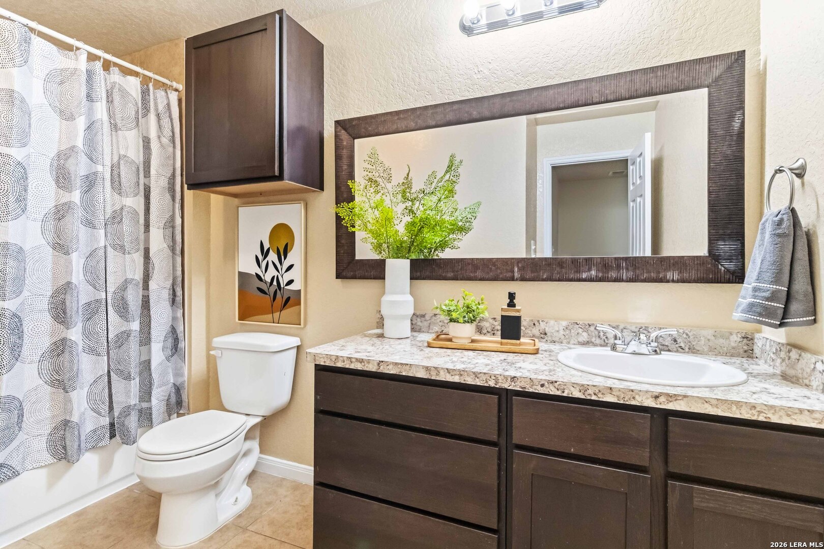 8711 8th Street, Unit 1 Converse, TX 78109 - Photo 19 of 25 a bathroom with a granite countertop sink mirror vanity and toilet