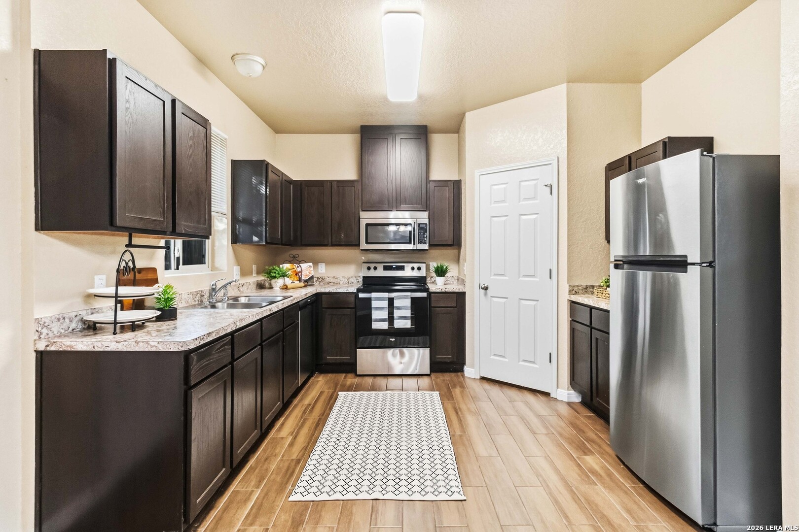 8711 8th Street, Unit 1 Converse, TX 78109 - Photo 6 of 25 a kitchen with stainless steel appliances granite countertop a refrigerator stove and oven