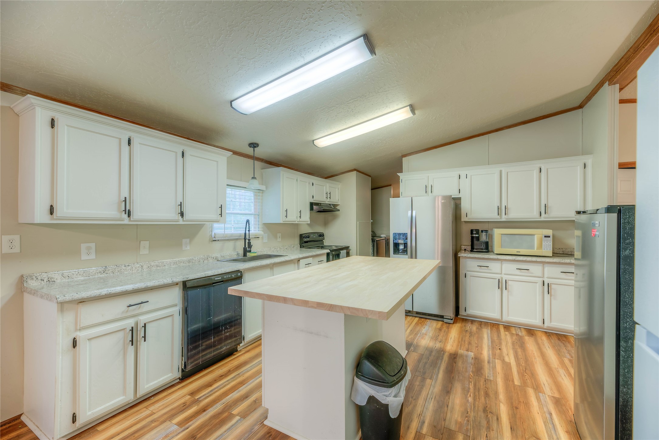 657 Parrish Road Livingston, TX 77351 - Photo 13 of 47 a kitchen with a sink a stove a refrigerator and white cabinets
