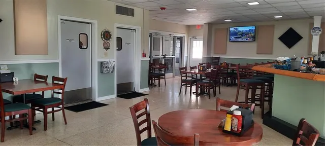 a room with lots of furniture and view of kitchen