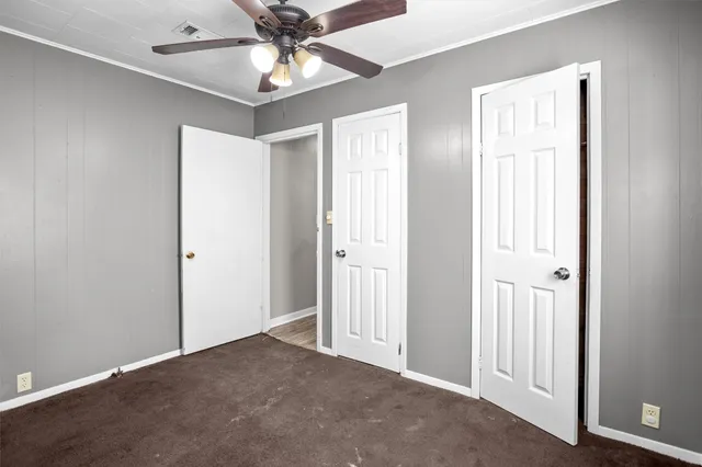 a view of an empty room and chandelier fan