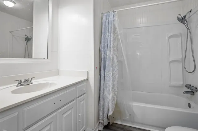 a bathroom with a granite countertop sink a toilet and shower