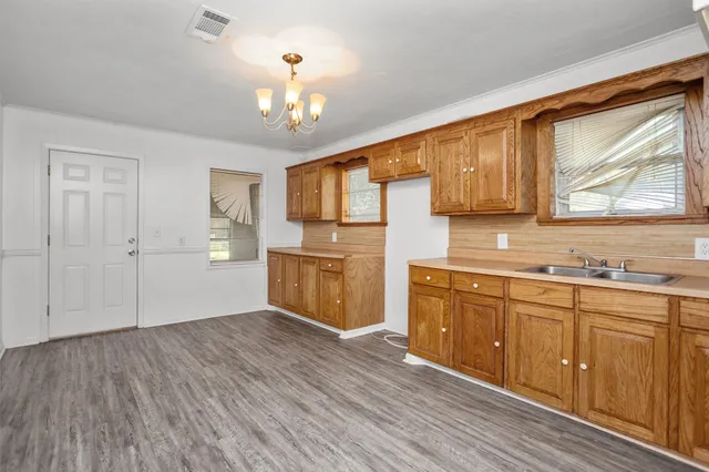 a kitchen with stainless steel appliances granite countertop a sink cabinets and wooden floor