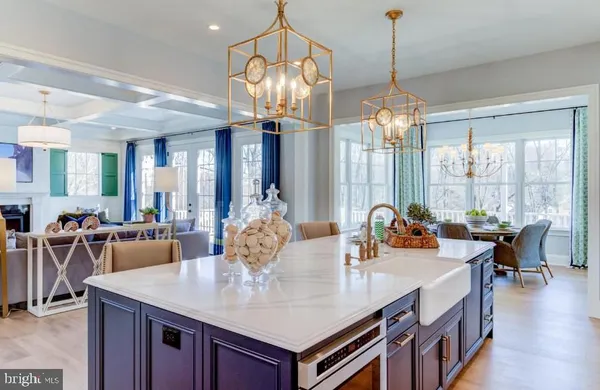 a view of a dining room and livingroom with furniture wooden floor a chandelier