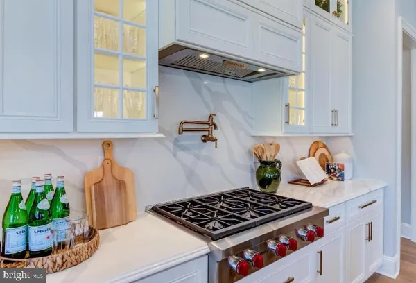 a kitchen with granite countertop a stove and a wooden floor