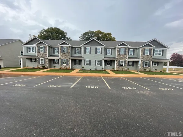 a front view of a house with a yard and swimming pool