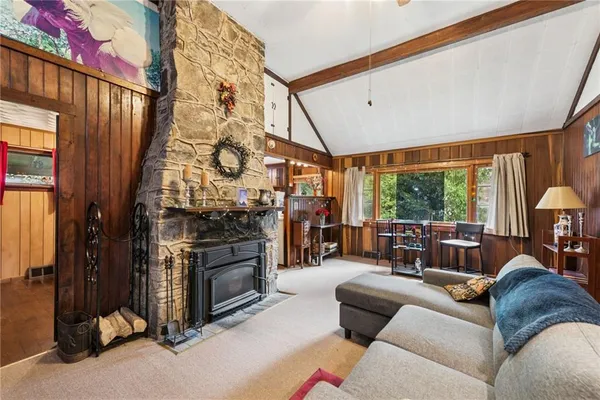 a living room with furniture a fireplace and a large window