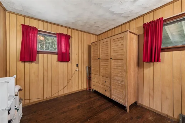 a view of a bedroom with wooden floor and windows