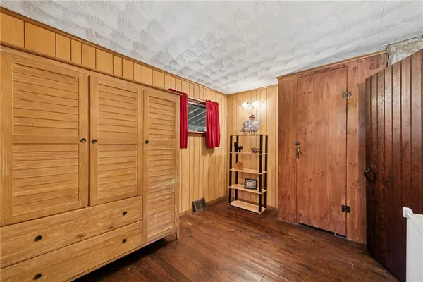 a view of a hallway with wooden floor and closet