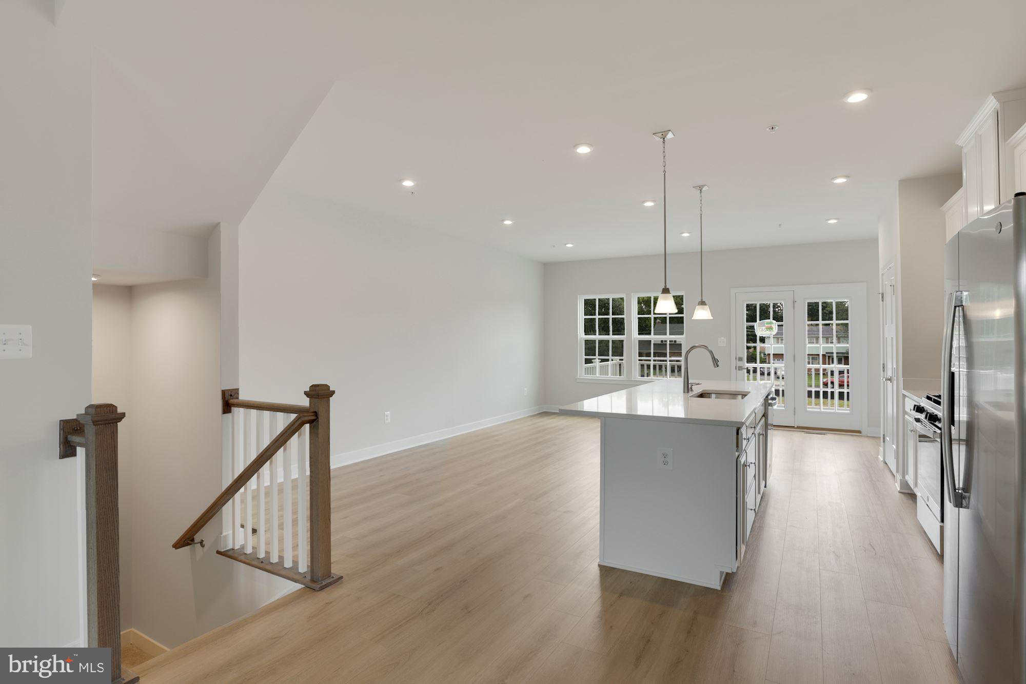 221 Edwin Road Frederick, MD 21702 - Photo 7 of 36 a open kitchen with stainless steel appliances granite countertop a refrigerator a sink a stove and white cabinets with wooden floor