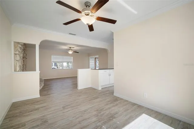 a view of an empty room with wooden floor and a fireplace