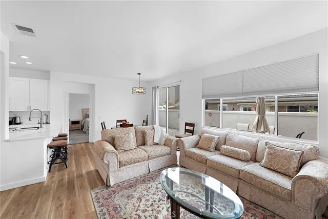 a living room with furniture wooden floor and a large window