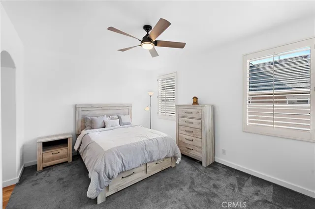 a bedroom with a bed a dresser and a window