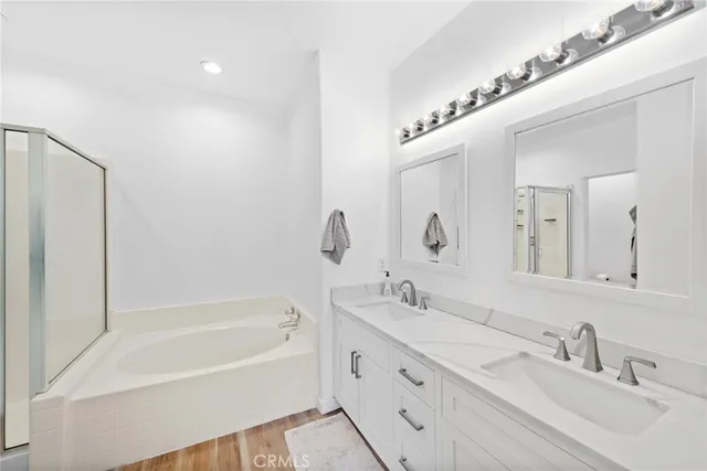 a bathroom with a double vanity sink mirror double and bathtub