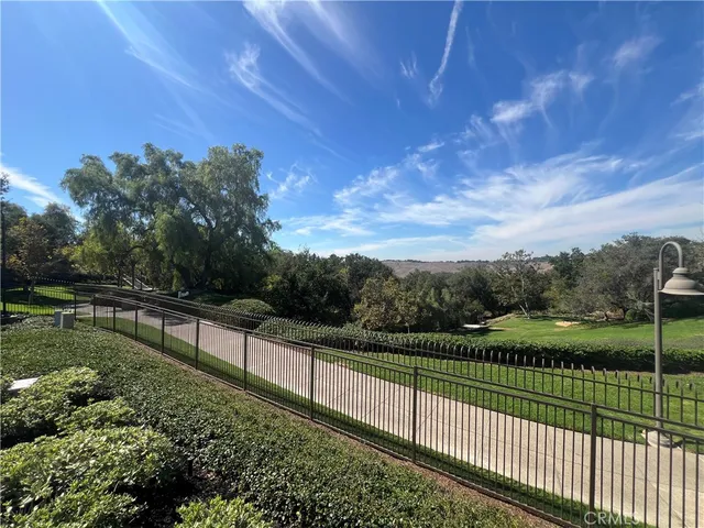 a view of a pathway with a wrought fence