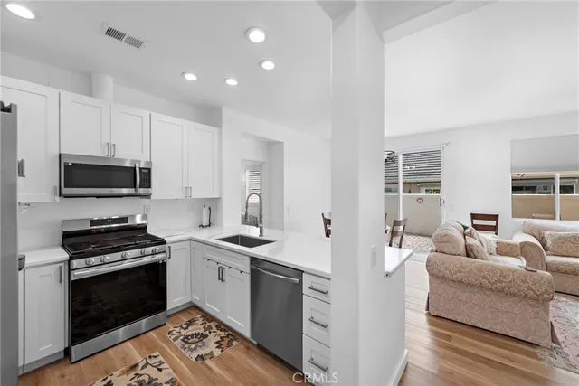 a kitchen with stainless steel appliances white cabinets and a stove top oven