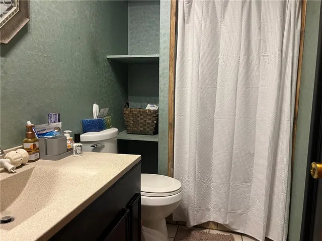 a bathroom with a sink a toilet and a mirror