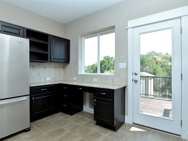 a kitchen with stainless steel appliances granite countertop a sink a stove and a refrigerator
