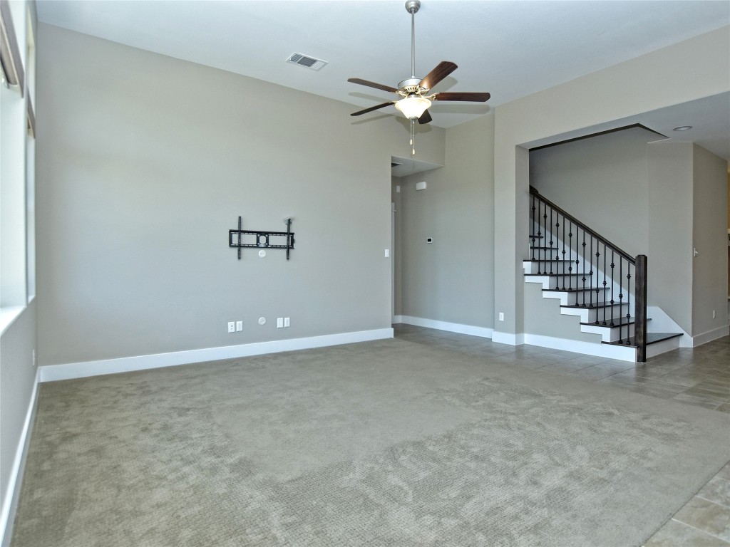 721 Clear Stream Crossing Austin, TX 78753 - Photo 11 of 24 an empty room with a chandelier fan and wooden floor