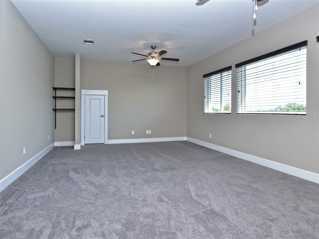 721 Clear Stream Crossing Austin, TX 78753 - Photo 18 of 24 an empty room with windows and fan