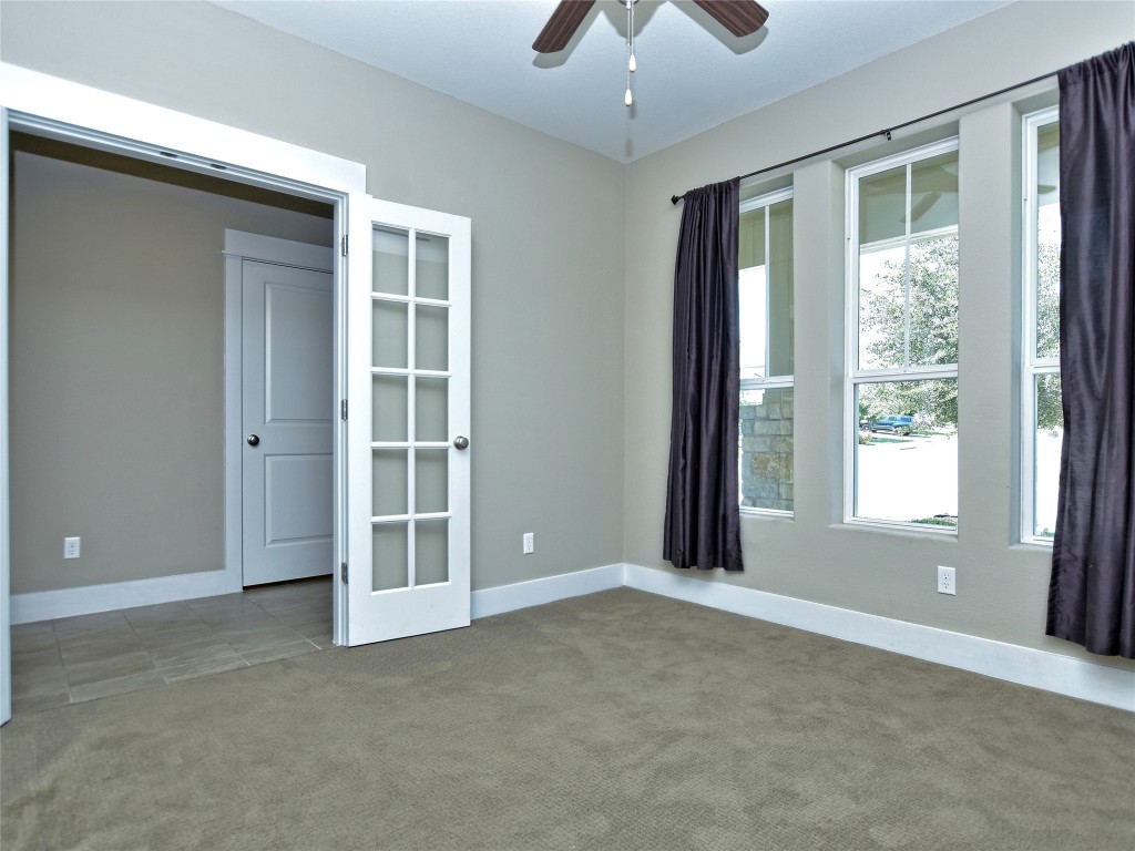 721 Clear Stream Crossing Austin, TX 78753 - Photo 5 of 24 an empty room with chandelier fan and windows
