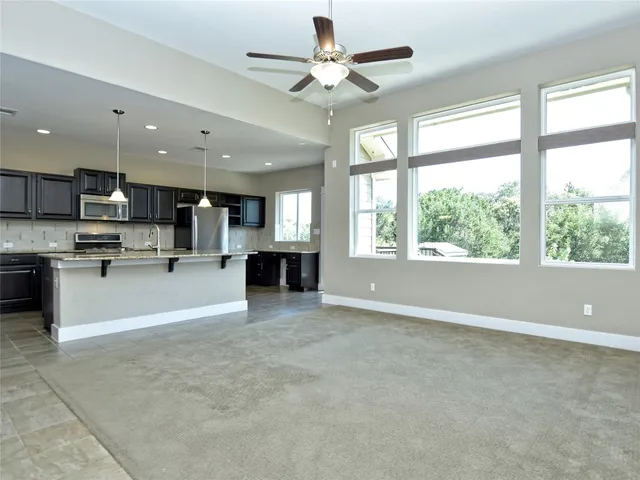 a spacious bathroom with a granite countertop sink a mirror and a bathtub with shower