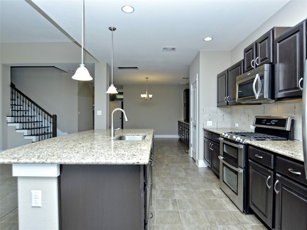 721 Clear Stream Crossing Austin, TX 78753 - Photo 9 of 24 a kitchen with stainless steel appliances granite countertop a sink a stove and a refrigerator
