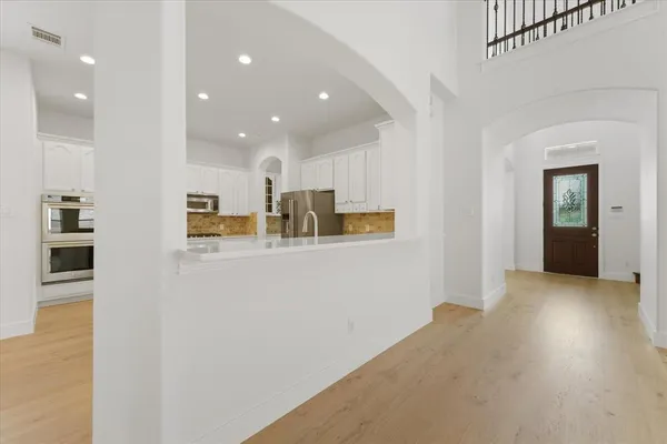 a view of a kitchen with refrigerator and wooden floor
