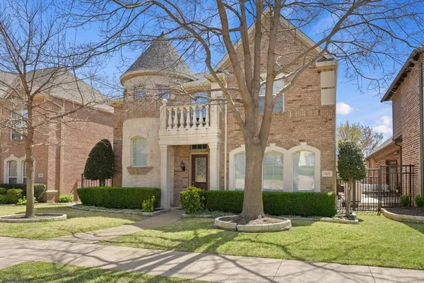 a view of a brick house with a yard in front of it