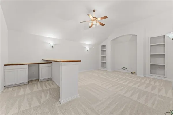 a view of an empty room with a chandelier fan