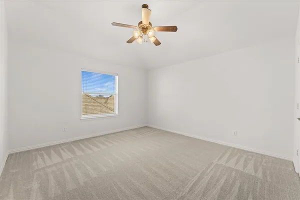 an empty room with a window and a fan