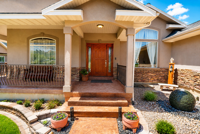 1055 North 1000 East Mapleton, UT 84664 - Photo 2 of 112 Stucco exterior featuring a covered entry, stone veneer accents, and an ornate wooden front door with sidelights