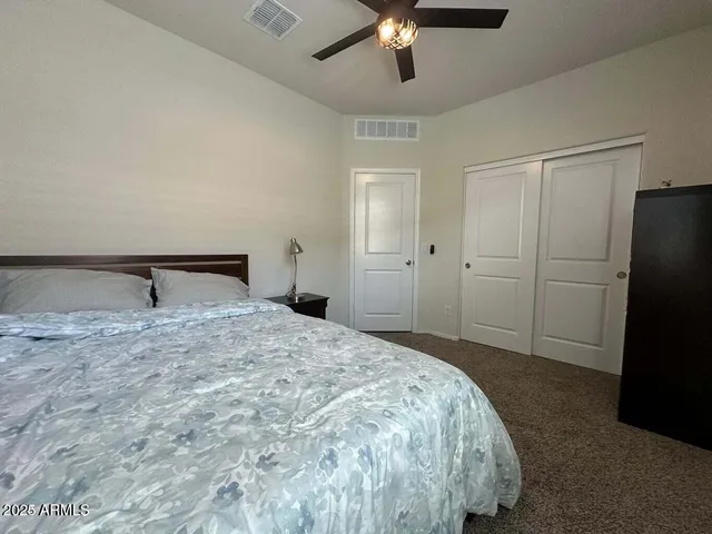 a spacious bedroom with a bed and a chandelier