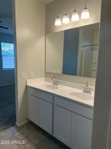 a bathroom with a double vanity sink and a mirror