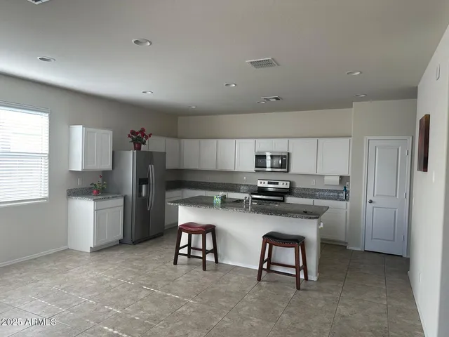 a kitchen with refrigerator cabinets and windows