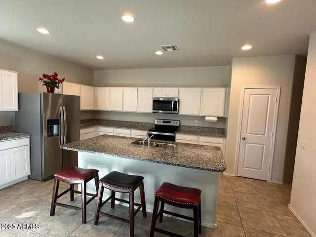 a kitchen with a refrigerator and a stove top oven