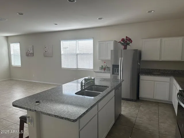 a kitchen with stainless steel appliances granite countertop a sink dishwasher and refrigerator