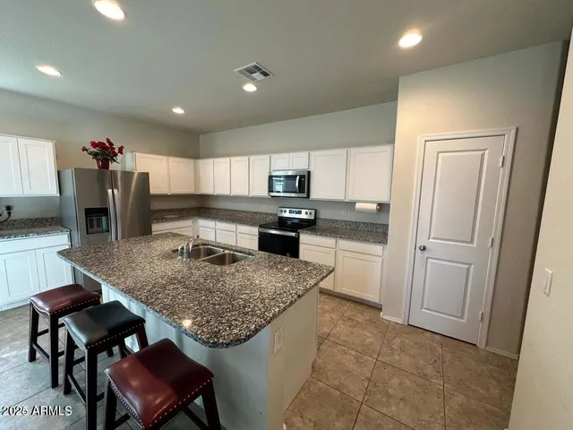 a kitchen with a table chairs refrigerator and microwave
