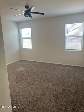an empty room with windows and fan view