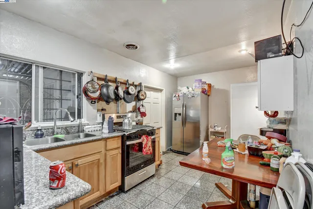 a kitchen with stainless steel appliances granite countertop a sink dishwasher and a stove with wooden floor