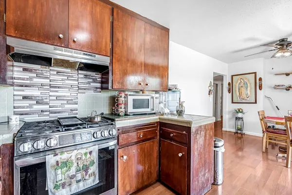 a kitchen with granite countertop a refrigerator and a stove top oven