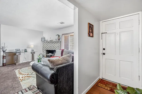 a living room with furniture a fireplace and a open kitchen view