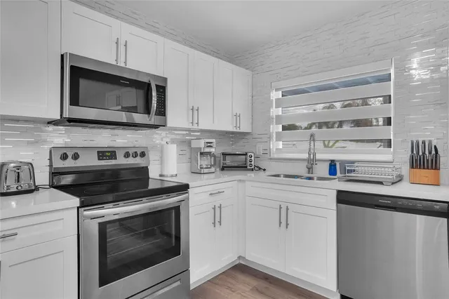 a kitchen with cabinets stainless steel appliances and a sink