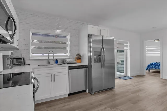 a kitchen with stainless steel appliances a refrigerator and a sink