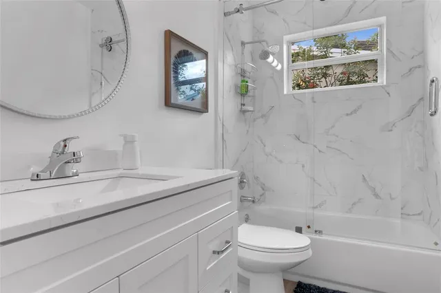 a bathroom with a granite countertop toilet a sink and a mirror