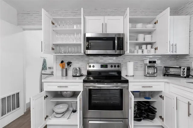 a kitchen with cabinets stainless steel appliances and a counter space