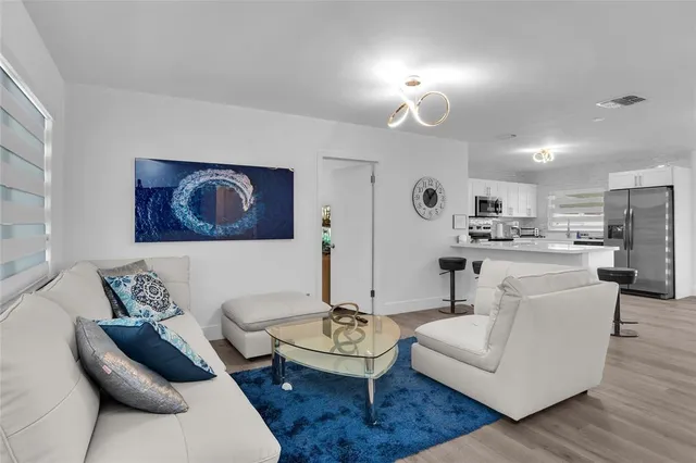 a living room with furniture and kitchen view