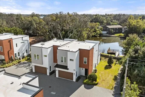 an aerial view of a house with a swimming pool and outdoor seating