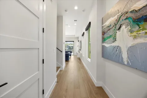a view of a hallway with wooden floor and staircase